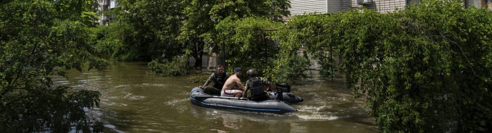 Ukrainian servicemen evacuate a man by a boat from a flooded neighborhood in Kherson, Ukraine, in June 2023.